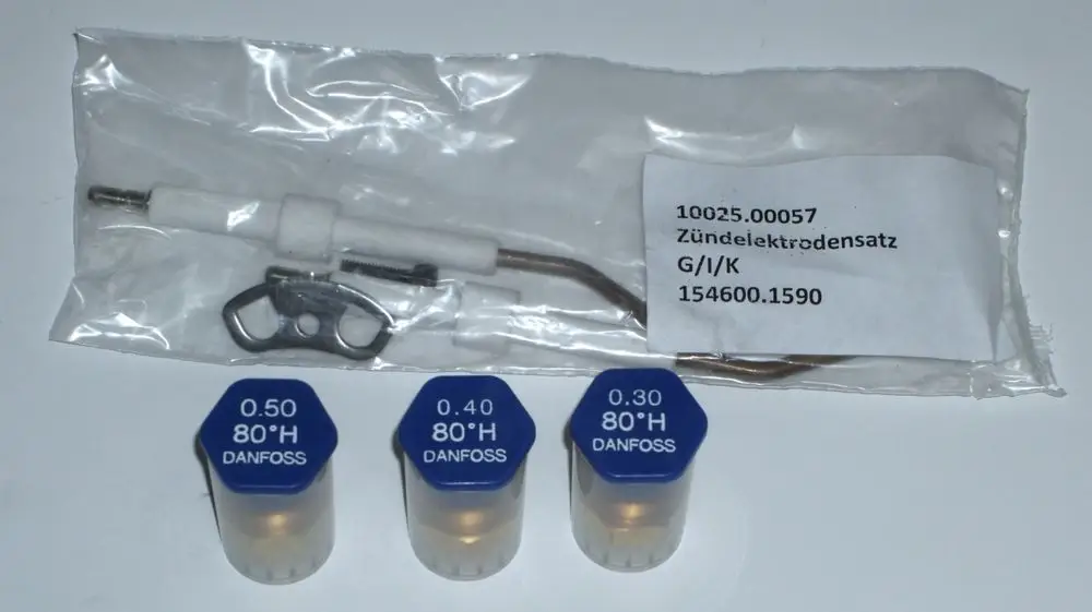 Drei blaue Danfoss-Düsen und ein Zündelektroden-Satz in einer Verpackung. Die Teile sind für Heizsysteme und können in Daikin-Anlagen verwendet werden.